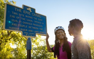 Cyclists stop along the trail in Albany to view a historic marker about the Erie Canal.